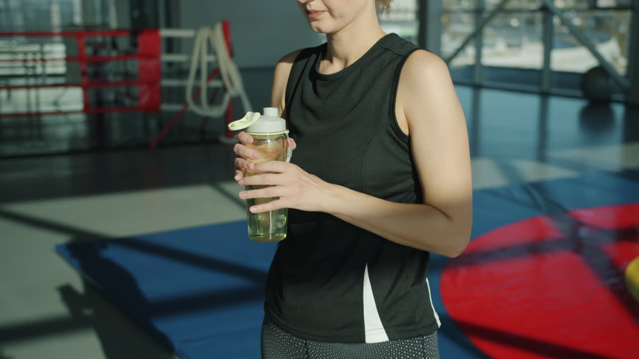 체육관 에서 물 을 마시는 여자