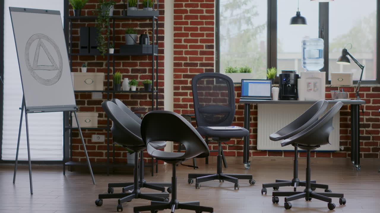 Empty office with aa meeting sign on white board and chairs in circle