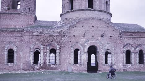 disabled person in front of an abandoned church