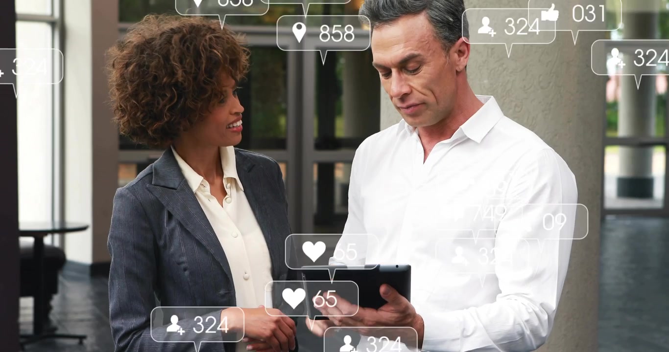 Colleagues tapping tablet outside office, swiping through animated social metrics icons for review
