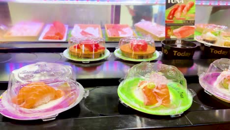 plates of sushi moving on a conveyor belt