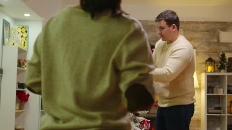 young man and woman decorate their christmas tree