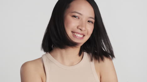 asian woman preening her hair on camera.