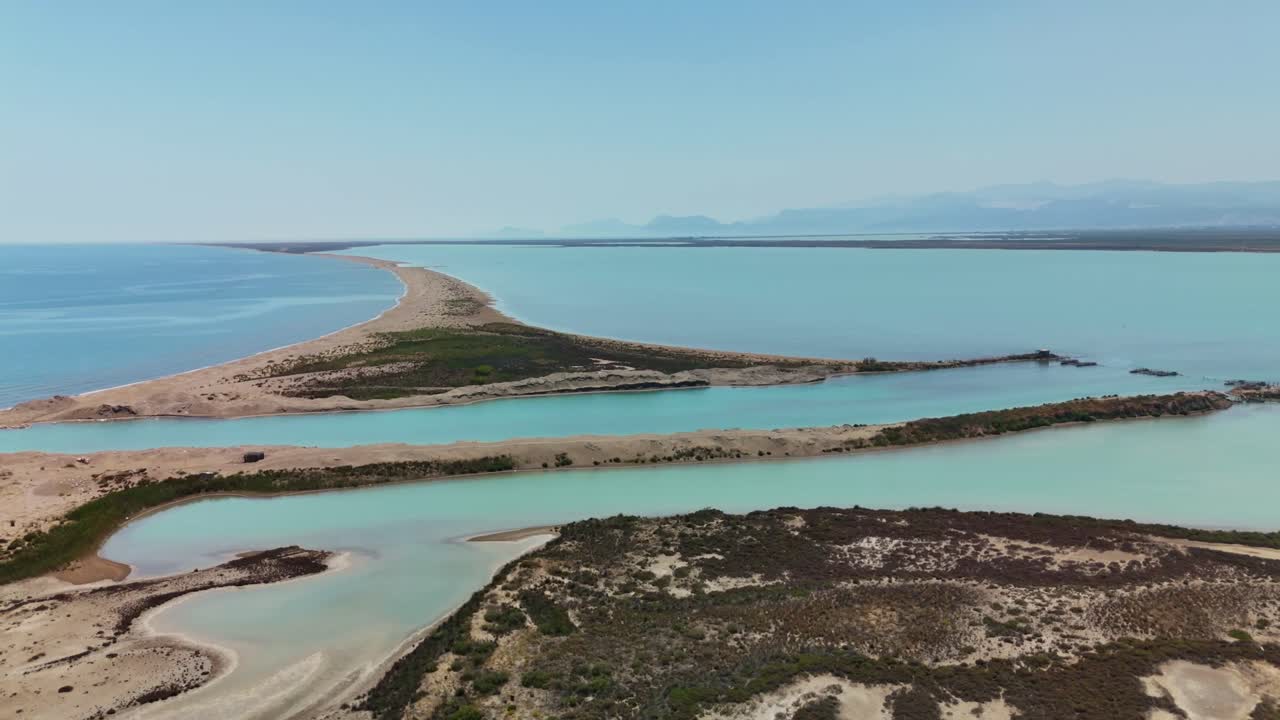 Aerial view of serene coastal landscape with clear blue waters and sandy shores