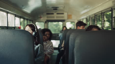 diverse students sitting schoolbus together. multiracial teenagers going home.