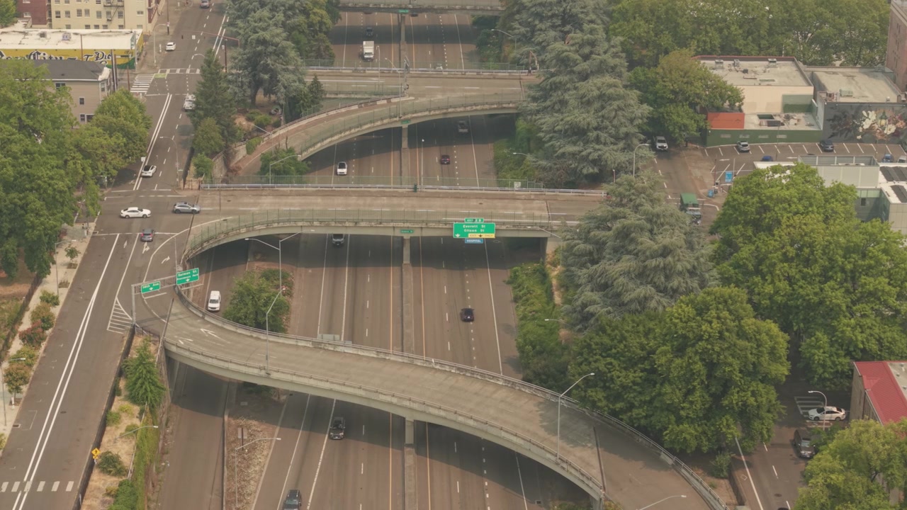 Portland, Oregon, Interstate 405 terlihat dari atas dengan jembatan layang jalan bebas hambatan, jalan landai melengkung, kendaraan bergerak, dan infrastruktur perkotaan multi-jalur di bawah kondisi berkabut