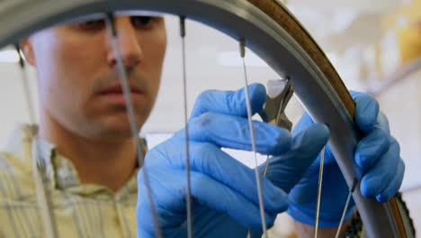 hombre reparando una bicicleta en el taller 4k