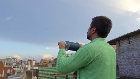 indian man flying kite using kite chakri