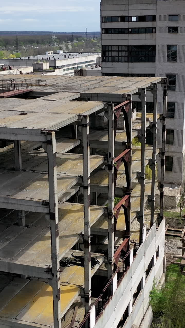 Destroyed buildings. Abandoned territory of an old industrial plant. Ancient factory with ruined buildings. Aerial flight. Vertical video