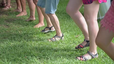 Beine-Einer-Gruppe-Von-Menschen,-Die-Gleichzeitig-Auf-Dem-Gras-Tanzen