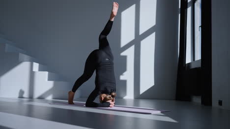 woman doing a headstand yoga pose