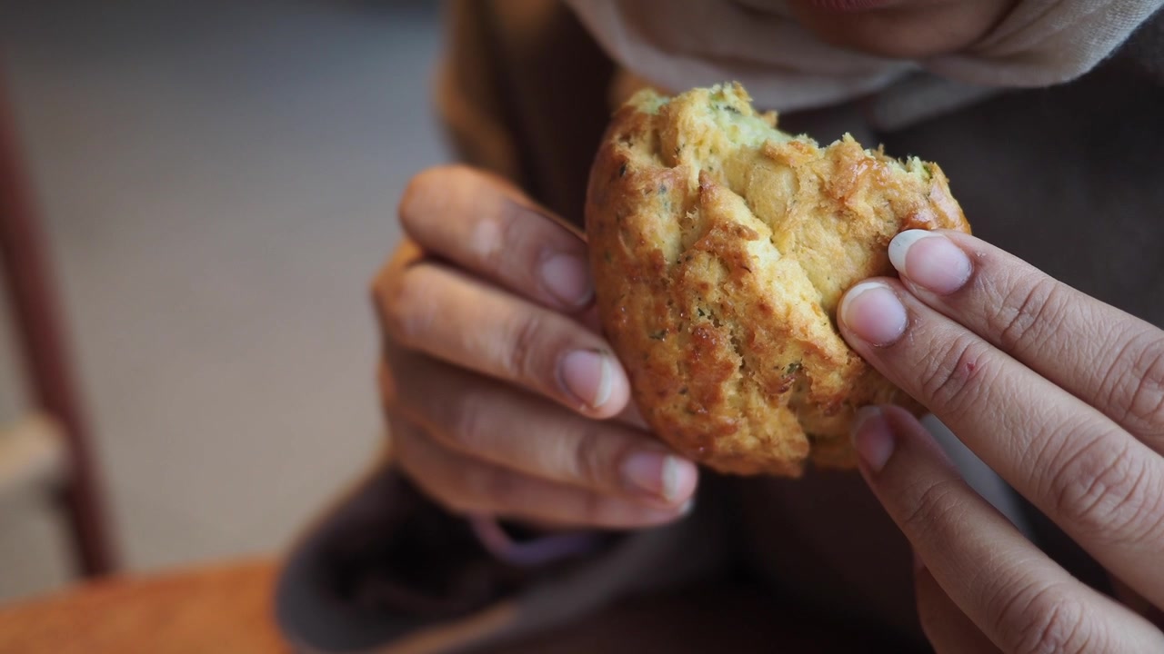 Person Holding a Freshly Baked Savory Scone
