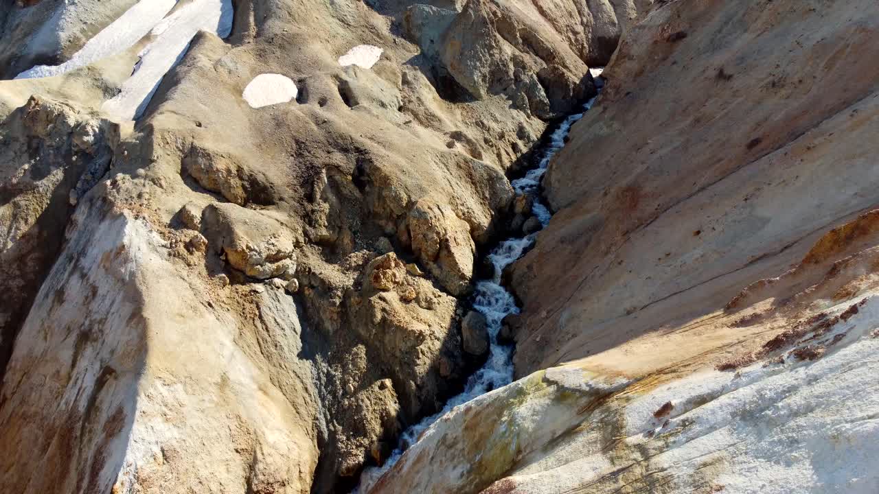 revelación aérea dinámica de un lago de montaña azul en un desfiladero en las espectaculares montañas de landmannalaugar en islandia