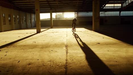 bmx rider in an empty warehouse