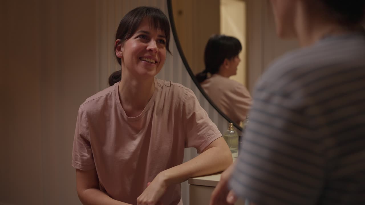 A woman talking to someone in front of a mirror