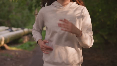 woman running on a trail in a forest