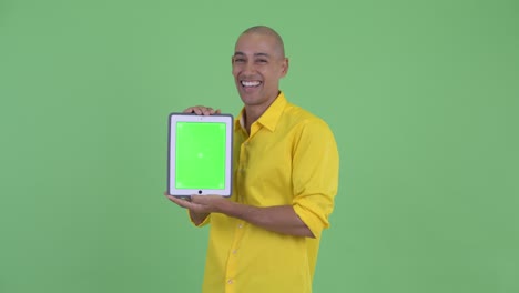 un hombre de negocios calvo feliz pensando mientras muestra una tableta digital