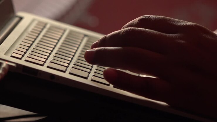 Kvindelige hænder, der taster og klikker på en bærbar computer