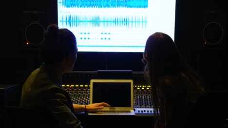 Audio-engineers-using-laptop-while-mixing-sound