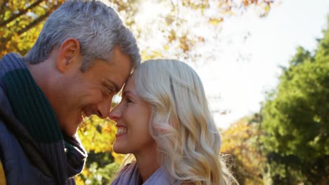 man and woman touching noses outdoors