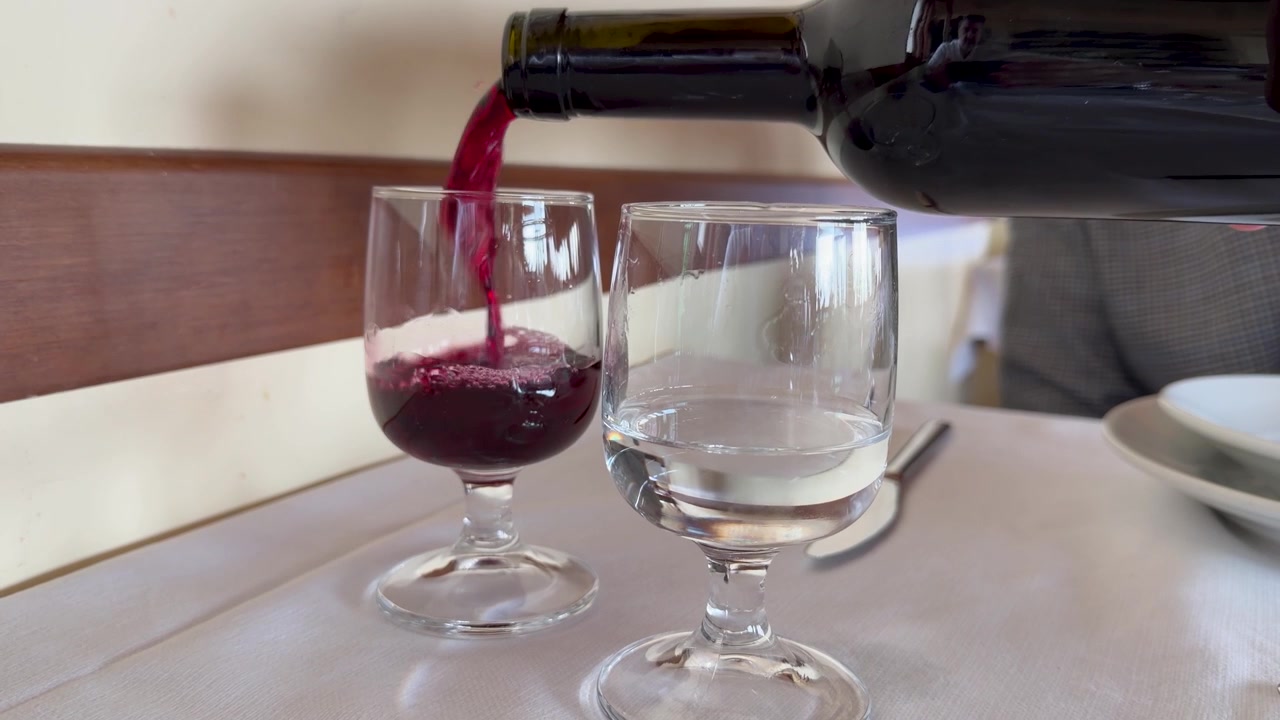 Vino tinto vertiéndose en una copa en un restaurante