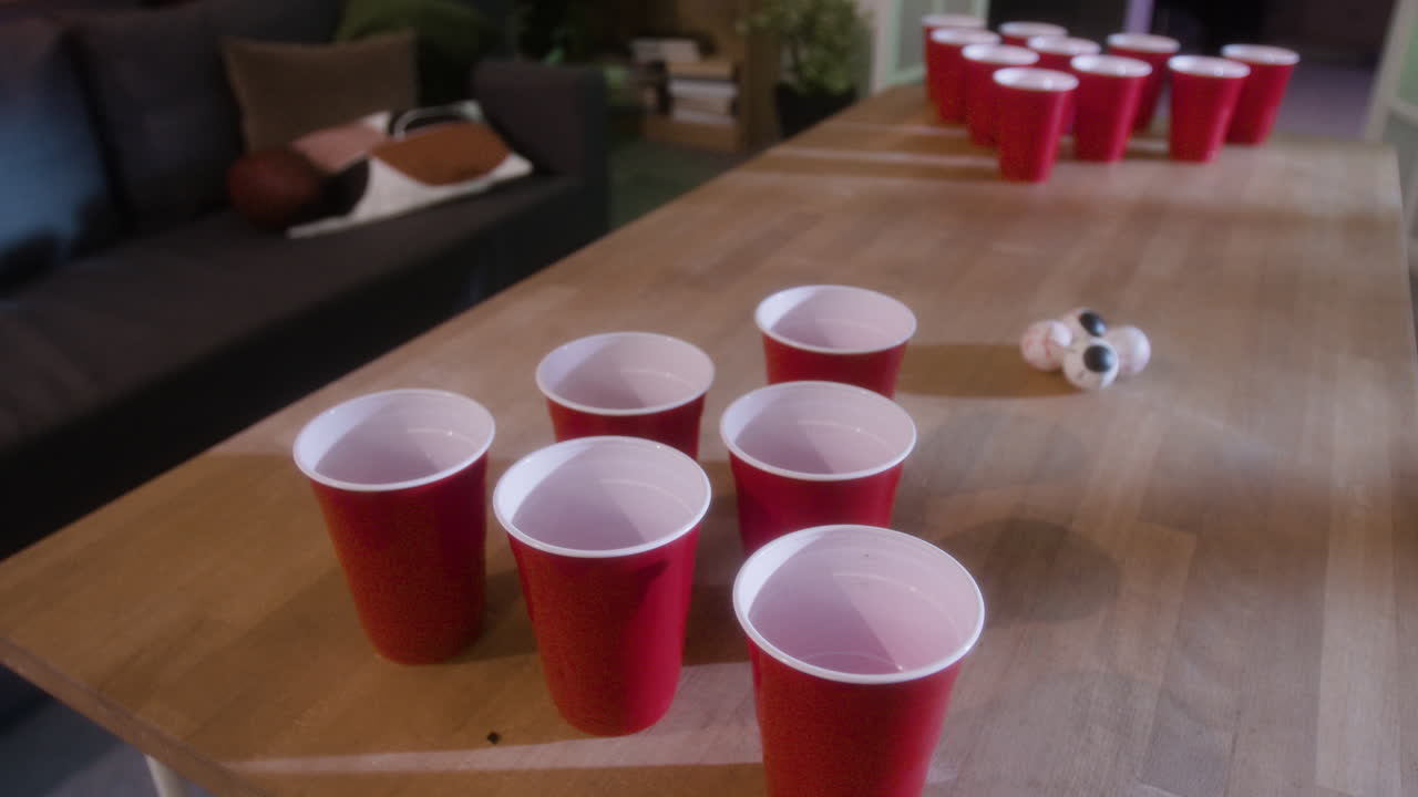 Beer pong setup with red cups and ping pong balls
