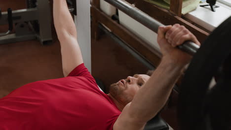 man doing bench press workout in a gym