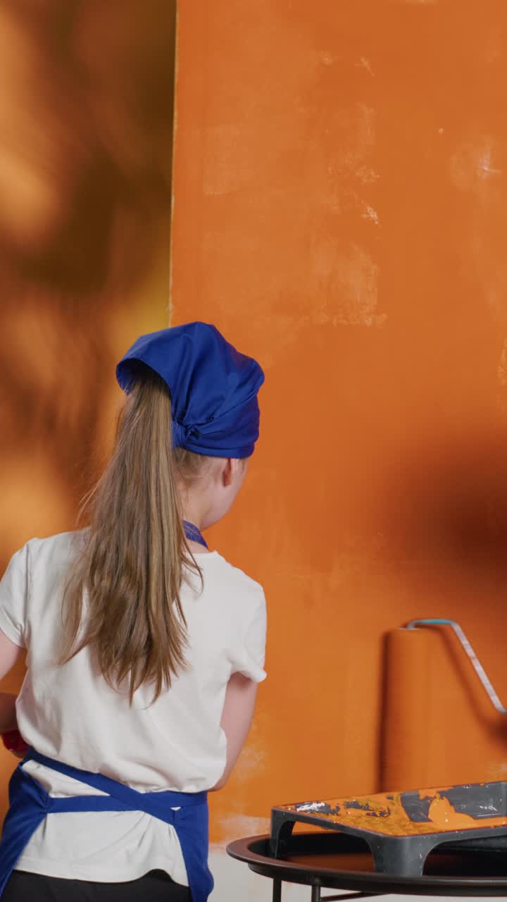 Kind dat een muur oranje verft