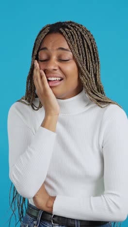 distressed young woman crying or in pain on blue background