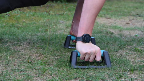un joven atleta de calistenia está haciendo una variación de flexiones de peso corporal en paralelos para hacer crecer su pecho y brazo