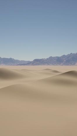 desert landscape with sand dunes and mountains in the distance