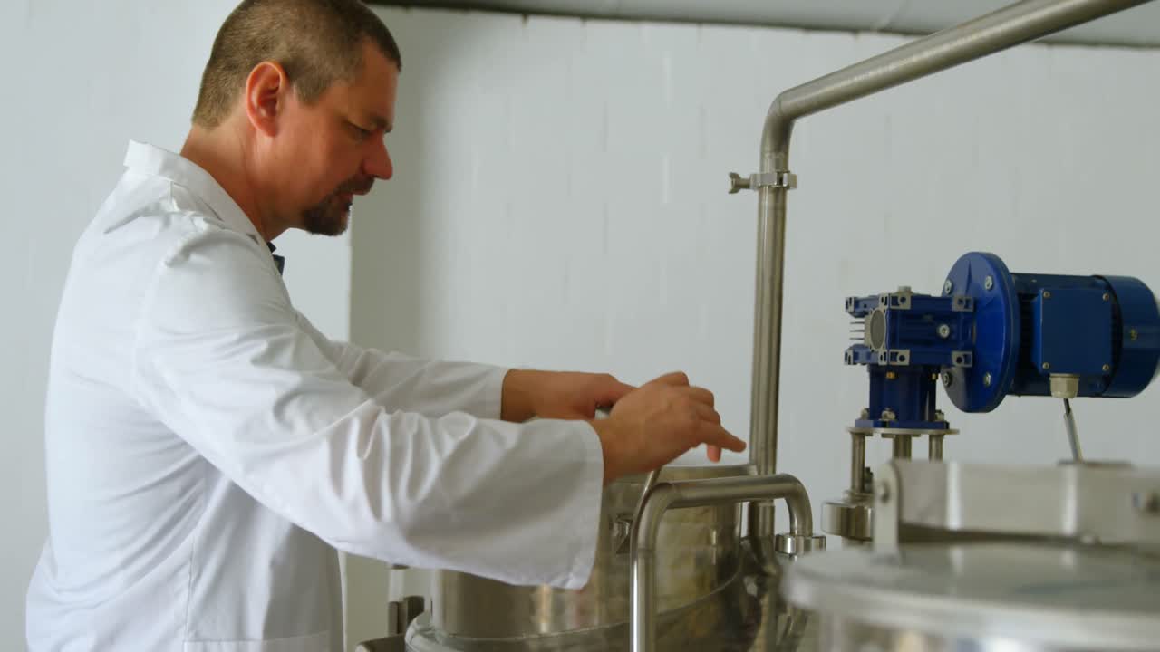 trabajador masculino comprobando el tanque de destilación en la fábrica 4k