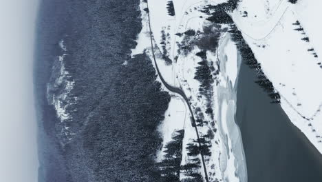 Vertical-format-aerial-video-of-Frumoasa-Dam-in-Romania-during-winter-snowfall