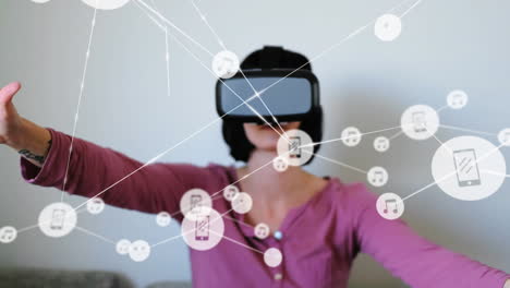 animation of network of connections with icons over woman wearing vr headset