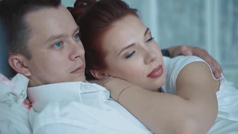 Young-beautiful-couple-resting-in-bed-looking-into-the-distance-closeup-1