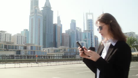 elegant businesswoman with phone outdoors