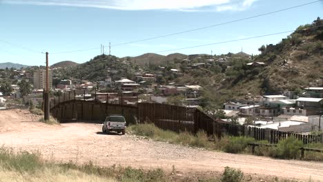 a mountainous desert community is bordered by a tall fence