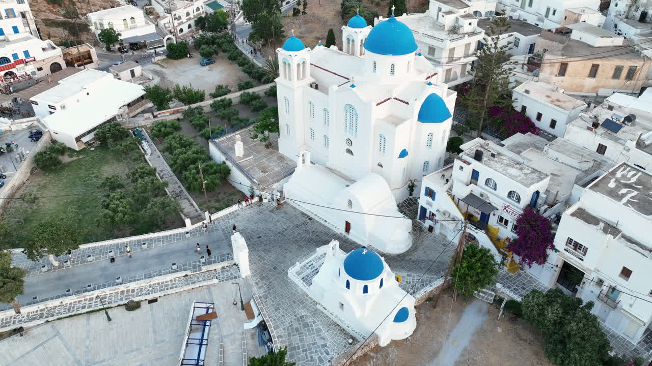 gente caminando por el sendero cerca de una iglesia al amanecer en la isla de ios, grecia