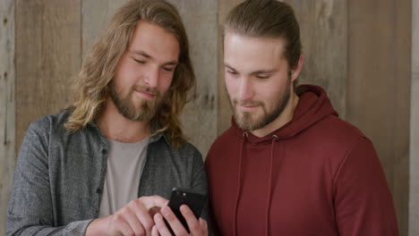 portrait of attractive twin brothers using smartphone browsing enjoying sharing mobile technology communication together smiling happy siblings slow motion