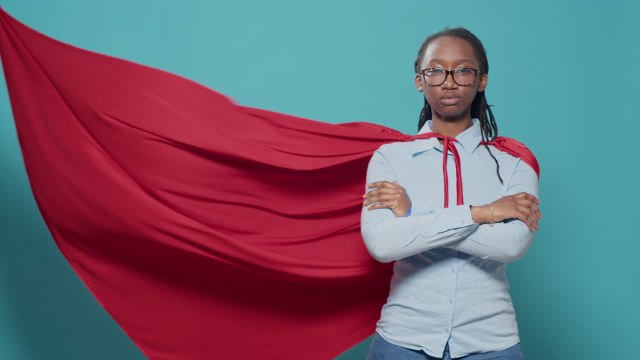 Woman superhero posing with arms crossed in studio