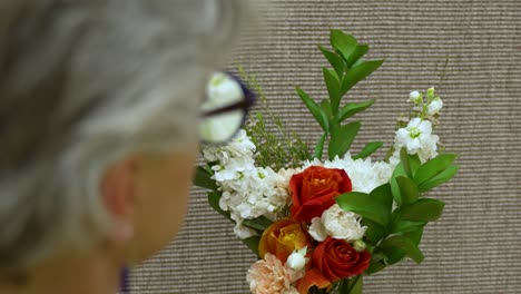 a florist makes the final adjustments on a bouquet of flowers