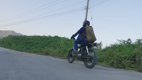 person riding retro motorcycle on a country road