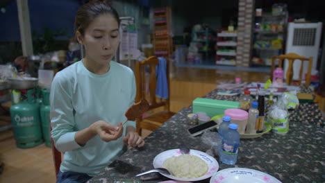 young woman having delicious lunch in a village of northern thailand, side angle shot