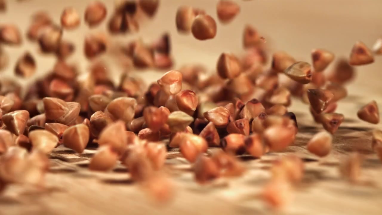 Buckwheat Grains Falling in Slow Motion onto a Wooden Surface