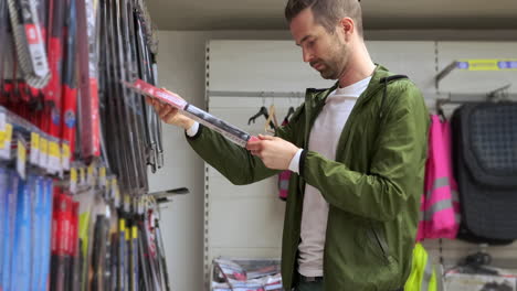 man shopping for car windshield wipers in an auto parts store