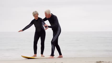 hombre maduro explicando a la mujer cómo surfear