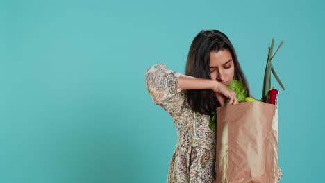 amante de la ecología sosteniendo una bolsa de compras con productos naturales