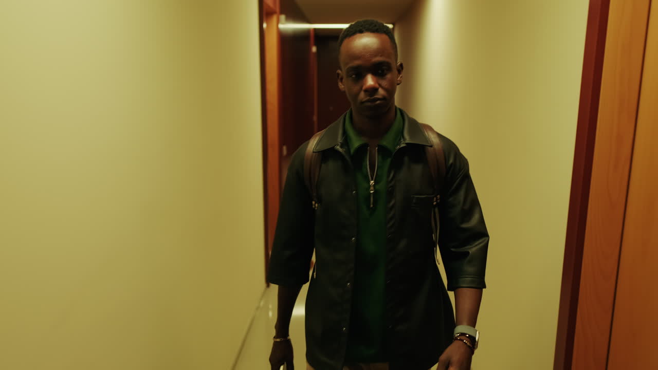 Serious Young Black Man Walking in a Dimly Lit Hallway