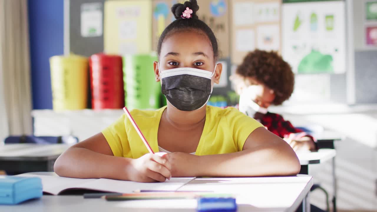 카메라 를 바라보는 교실 에서 얼굴 마스크 를 착용 한 혼합 인종 여학생 의 초상화