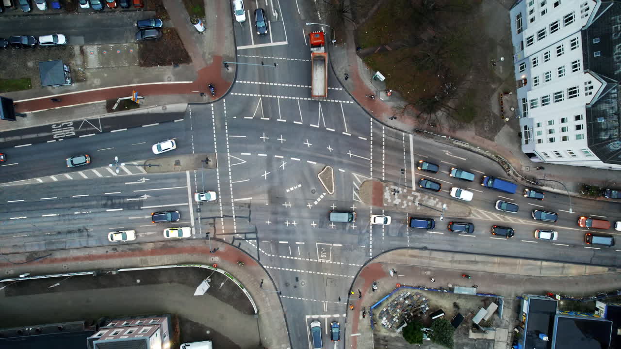 Aerial drone vertical view of a crossroad in Hamburg, Germany. Moving cars, bare trees, buildings